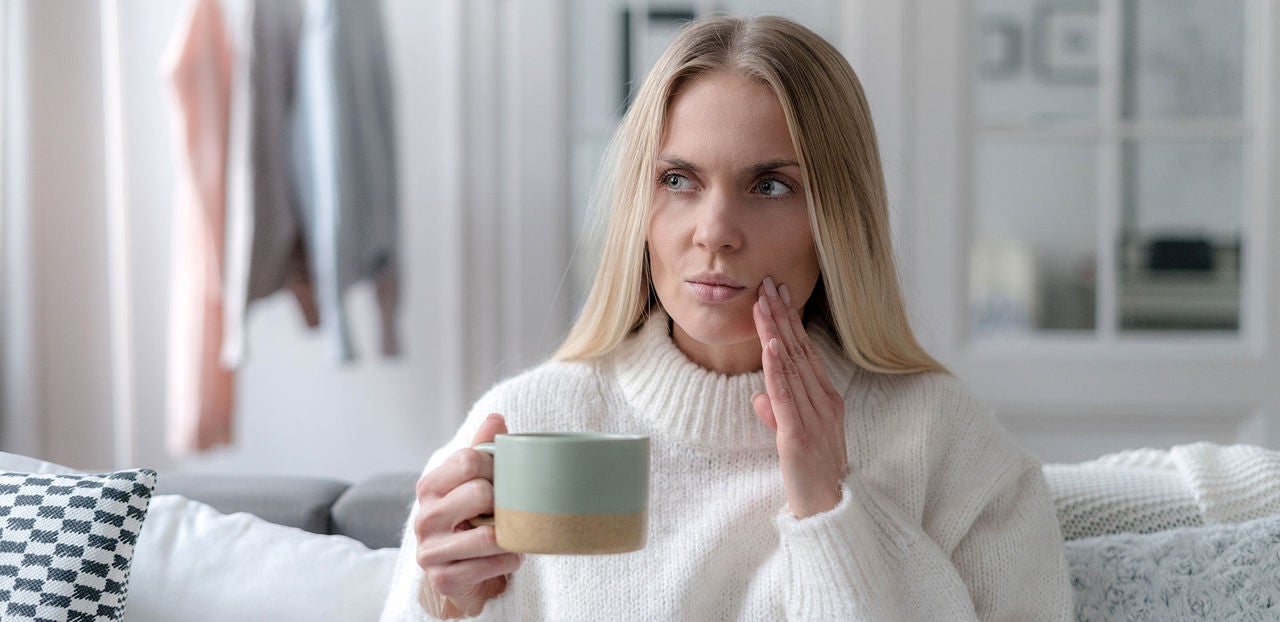 worried young woman with sensitive teeth feeling discomfort